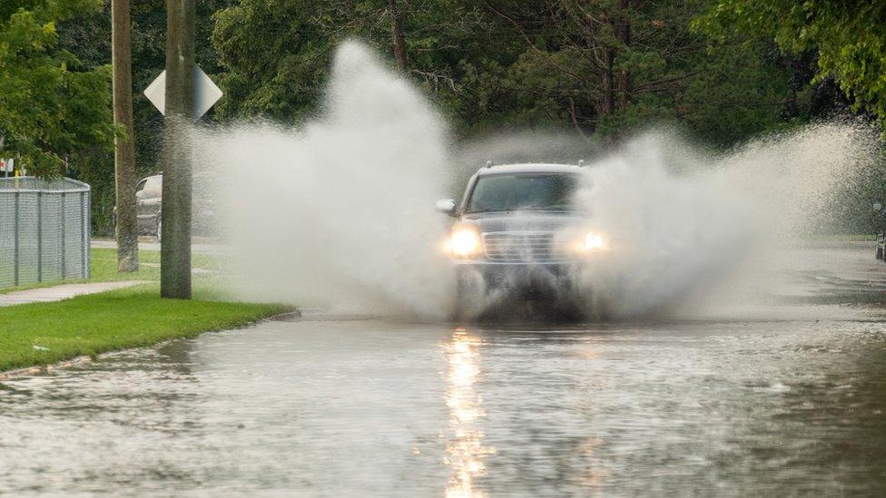 Car travelling through flood after extreme rain