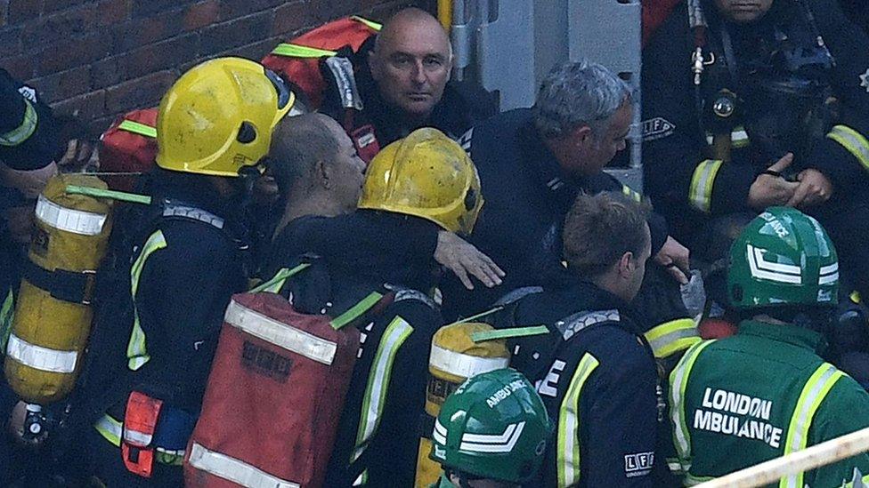 A man is rescued from the fire by fire fighters and paramedics