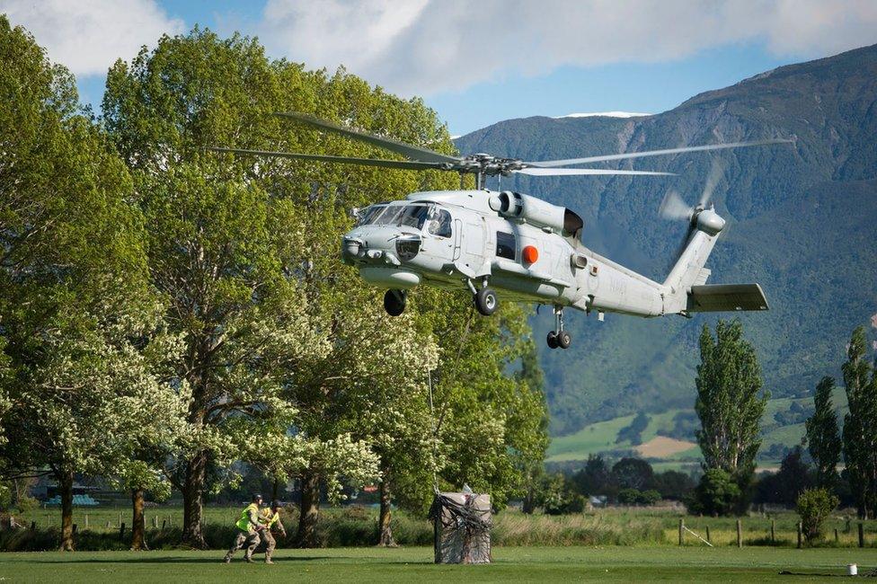 A handout picture made available by the New Zealand Defence Force (NZDF) shows a Seahawk helicopter landing supplies in Kaikoura on 18 November 2016.