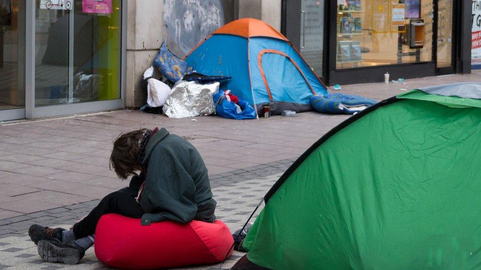 A man sits with his head in his hands in front of a tent on Queen Street on January 3, 2019 in Cardiff