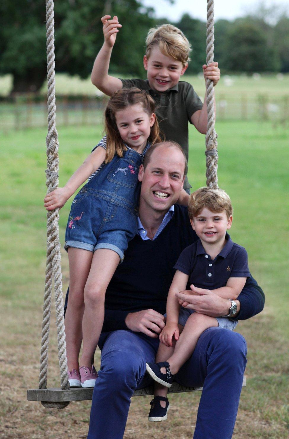 The Duke of Cambridge poses on a swing with Prince George, Princess Charlotte and Prince Louis