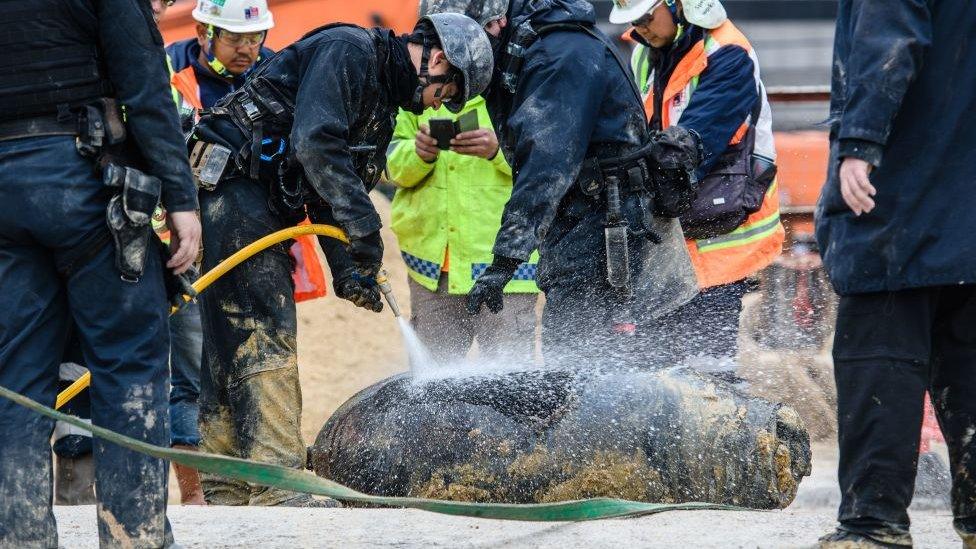 Police from the explosive ordinance disposal unit hose down a defused US-made bomb