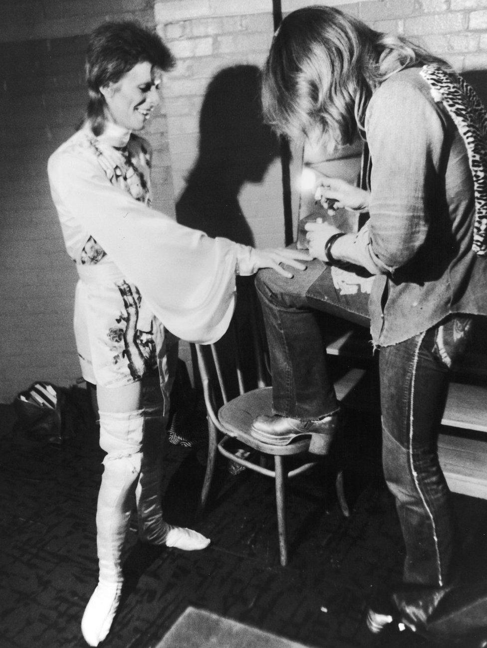 Make-up artist Pierre La Roche prepares English singer David Bowie for a performance as Aladdin Sane, 1973. Bowie is wearing a costume by Japanese designer Kansai Yamamoto