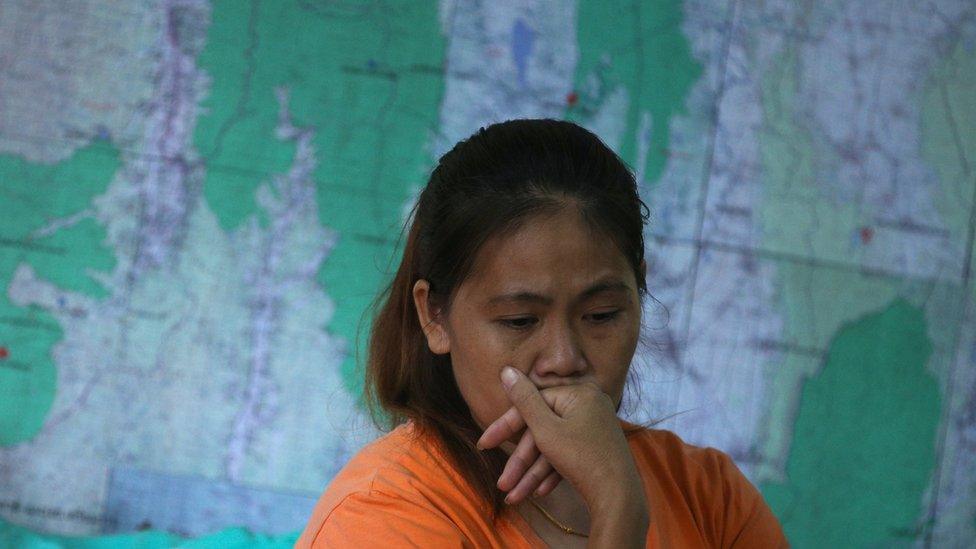 A relative of one of the 12 boys listens to a news conference announcing the diver's death