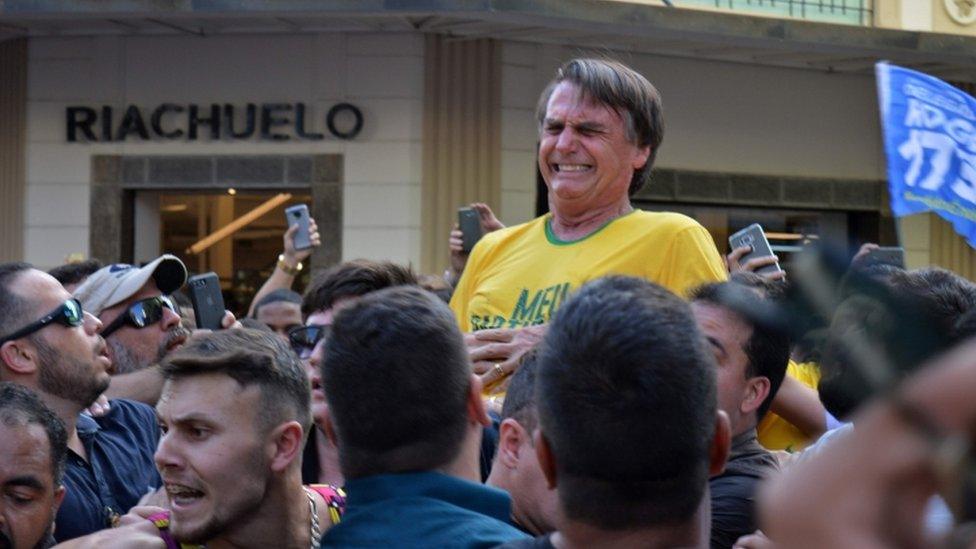 Brazilian right-wing presidential candidate Jair Bolsonaro gestures after being stabbed in the stomach during a campaign rally in Juiz de Fora, Minas Gerais State, in southern Brazil, on September 6, 2018.