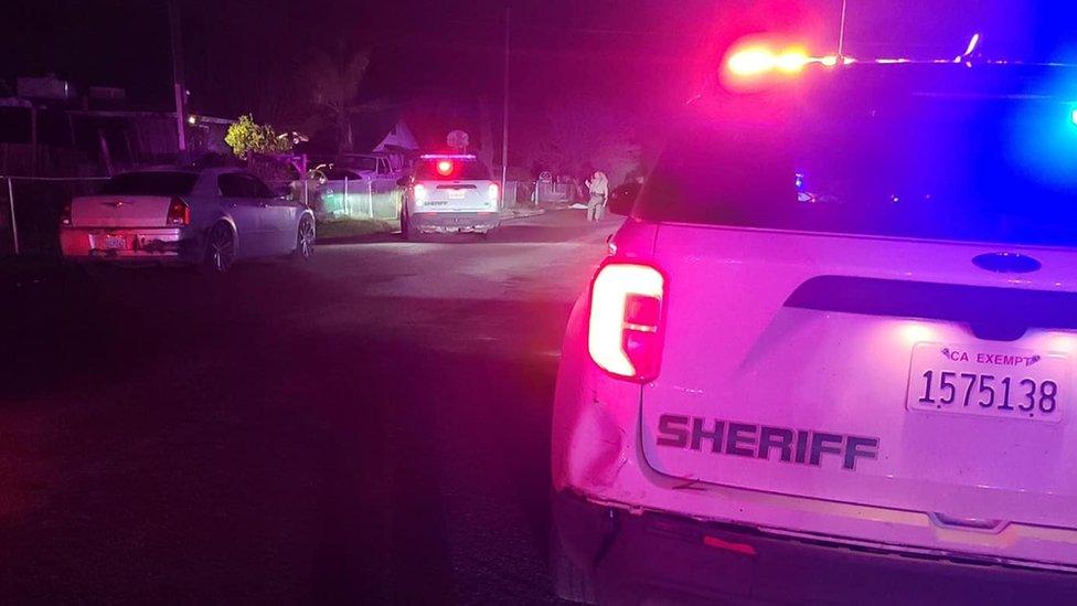 Police cars outside the home where six people were shot in Goshen, California