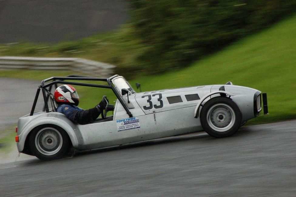 A Caterham drives up a hill