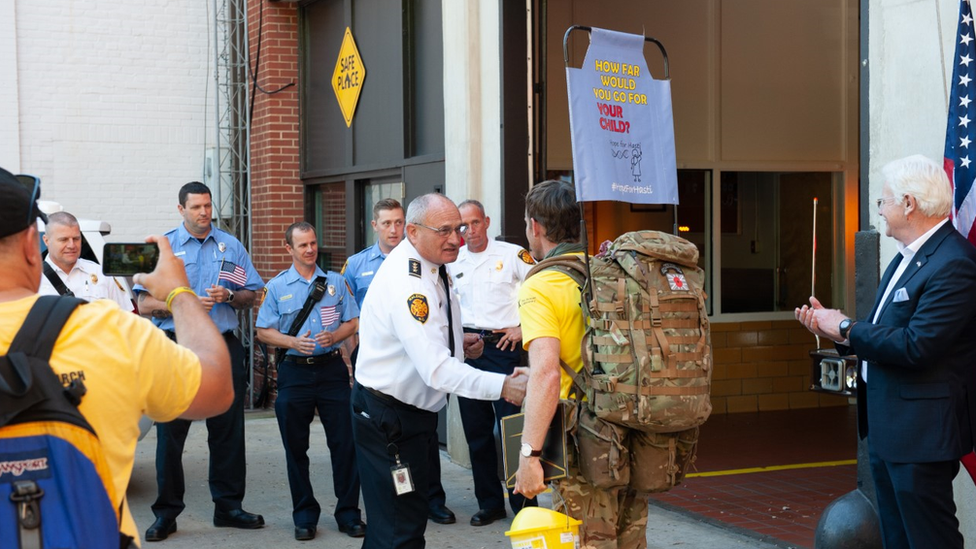 Major Chris Brannigan at the finish line in North Carolina. He is shaking hands with a member of the Police department.