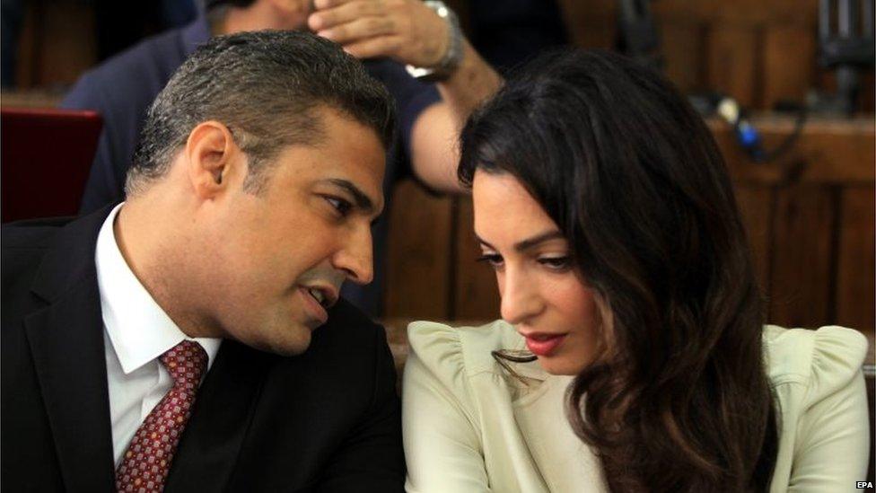 Al-Jazeera journalist Mohamed Fahmy (L) and lawyer Amal Clooney (R) attend a court session, in the Tora prison in Cairo, Egypt, 29 August 2015