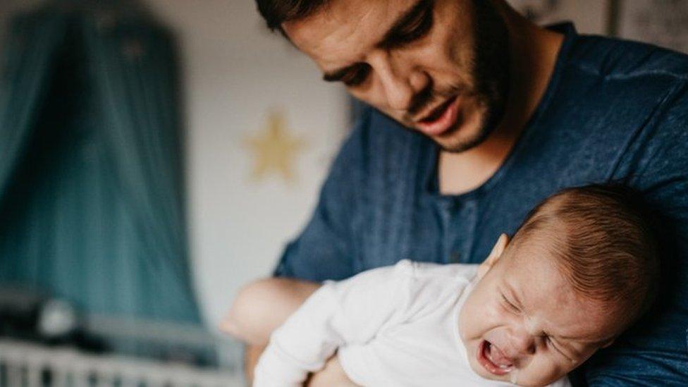 Father holding crying baby