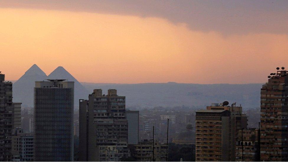 The sun sets behind the Great Pyramids of Giza during December