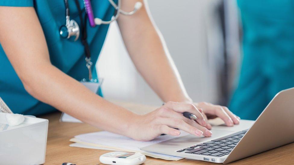 A nurse looking at a computer