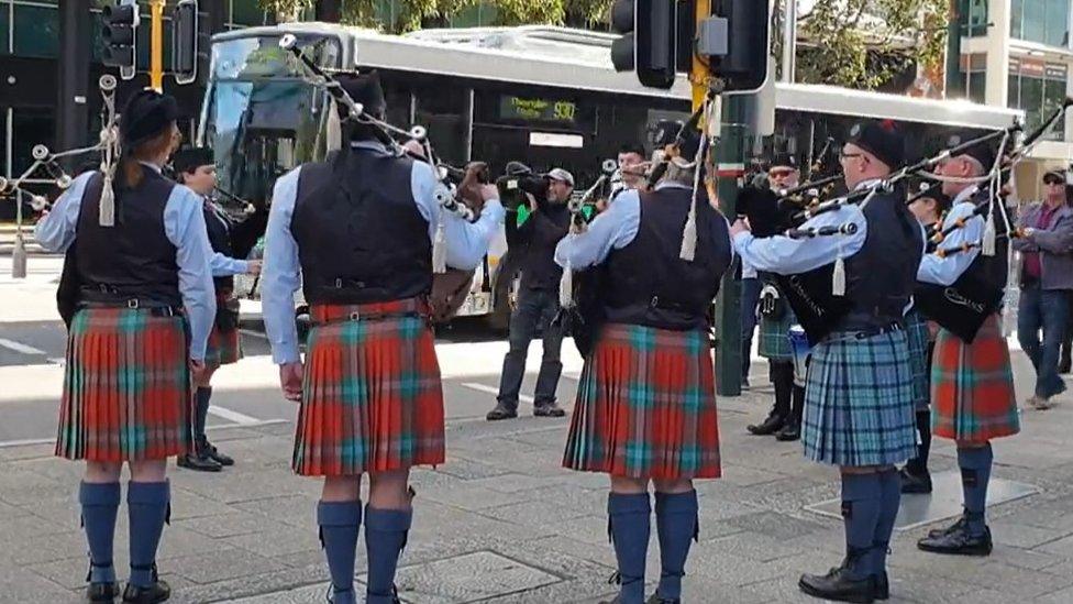 A Scottish pipe band play in tribute to Danny Hodgson