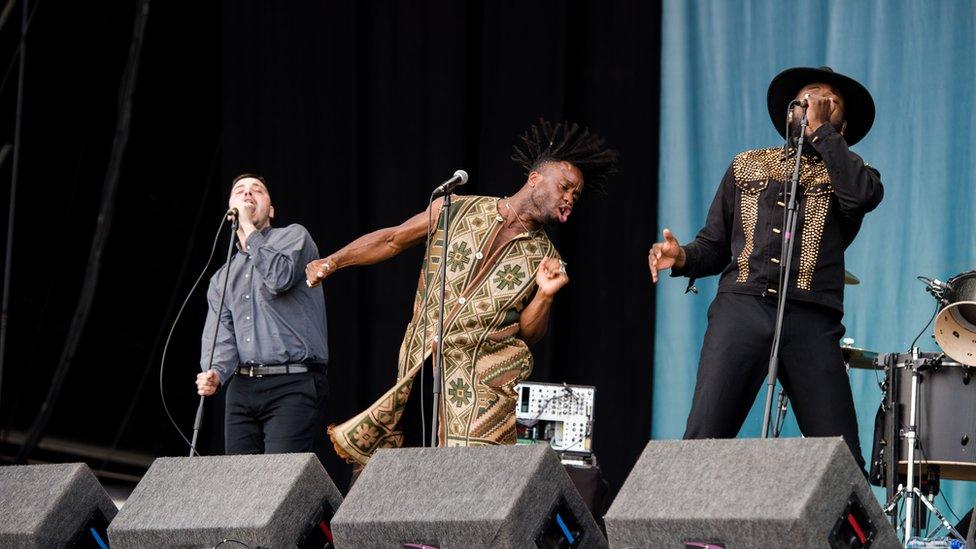 The band members of Young Fathers onstage