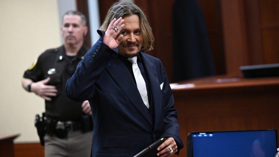 US actor Johnny Depp waves inside the courtroom during his defamation trial against Amber Heard