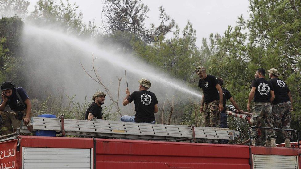 Fire fighters spray water at a fire in Lebanon