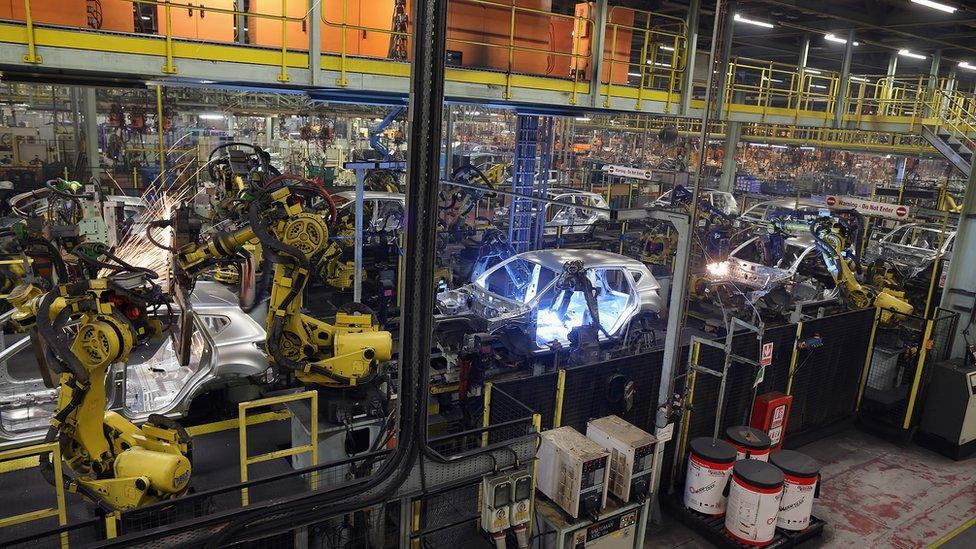 Robotic arms assemble and weld the body shell of a Nissan car on a production line