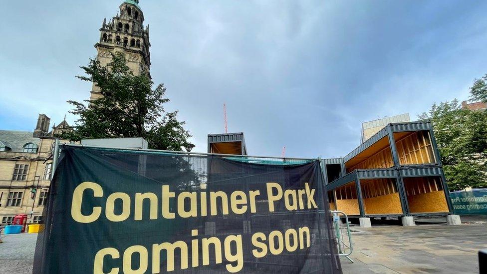 Image of a sign saying 'coming soon' at the container park site