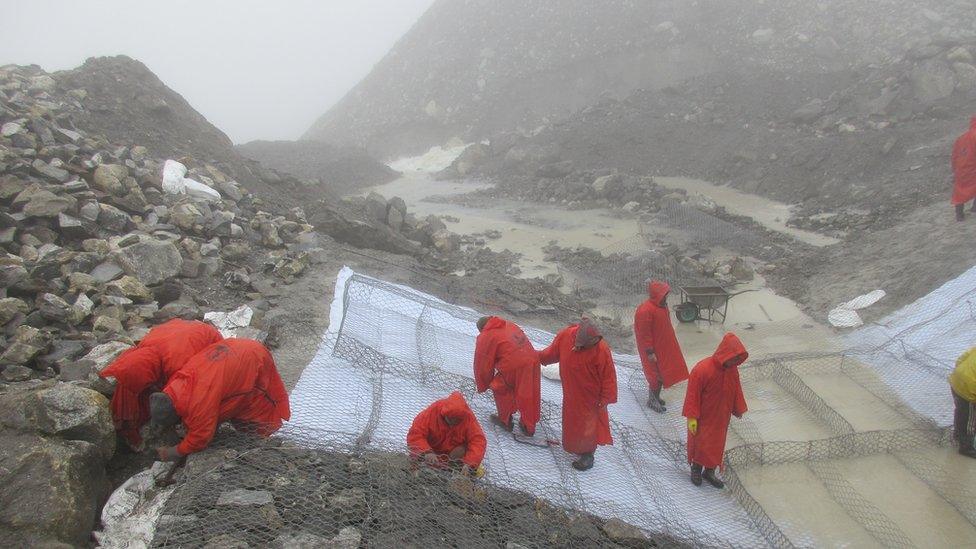 Personnel working at the lake in foggy conditions