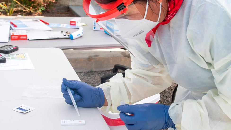 A woman carries out a coronavirus blood test that can produce results within 15 minutes