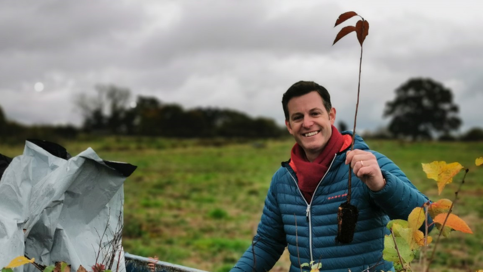 Matt Baker holding a sapling.