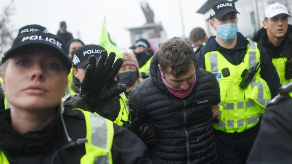 Police detain a protestor outside the COP26 climate conference in Glasgow