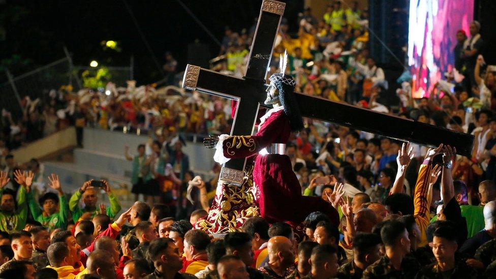 The Black Nazarene and cross on a carriage, surrounded by thousands of devotees. 9 January 2017, Manila, Philippines.