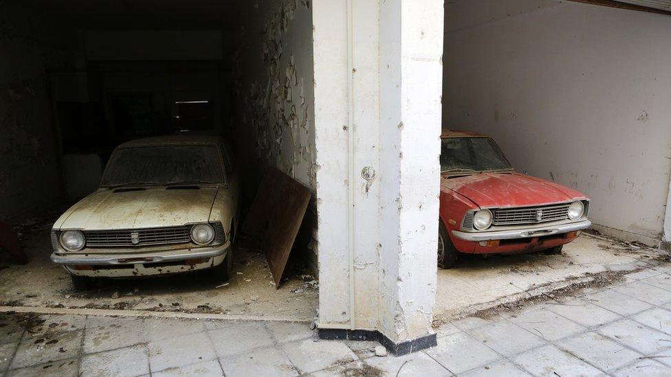 In this Wednesday, Jan. 4, 2017 photo cars from the 1970s in an abandoned show room inside the UN buffer zone, Green Line that divided Cyprus