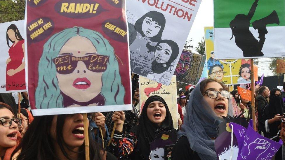 Pakistani civil society activists carry placards and shout slogans during a rally for women rights on International Women's Day in Lahore on March 8, 2019.