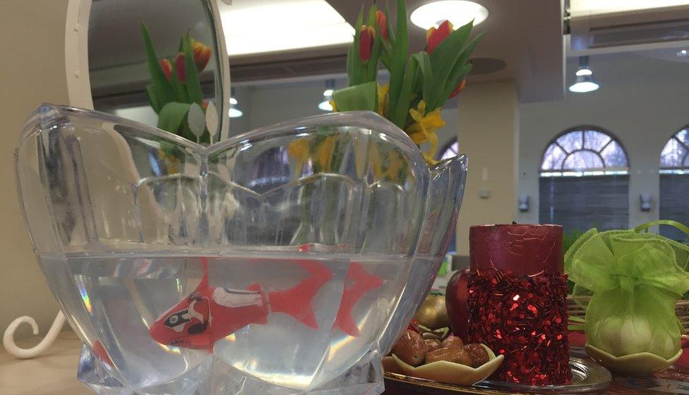 A photo of a Haft Seen table with a plastic goldfish in a bowl