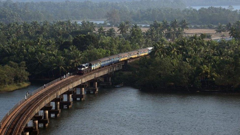 This photograph taken on July 1, 2015 shows an Indian Railways diesel locomotive carrying a passenger train on Sherawati bridge near Honnawar in Karnataka.