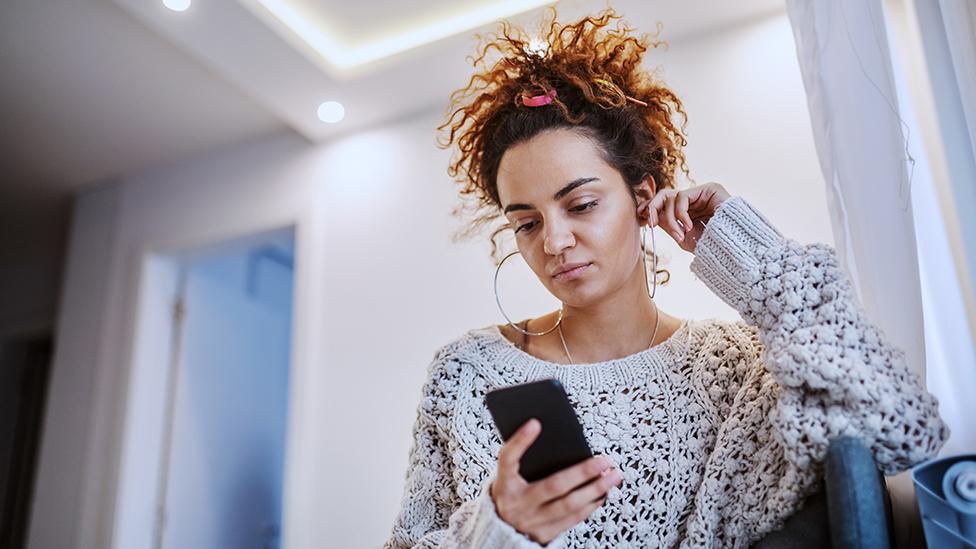 Young woman using mobile phone at home