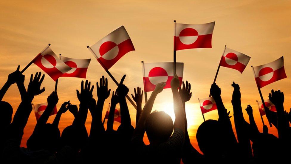 People waving Greenland flag