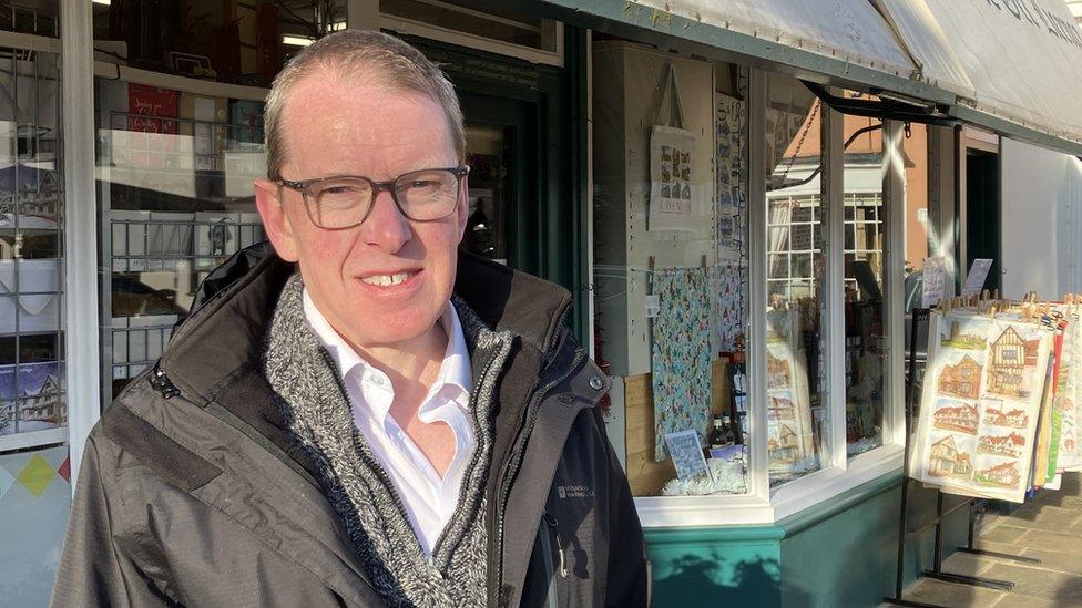 John Heeks wearing a coat outside his shop A R Heeks in Lavenham