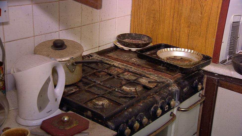 A filthy kitchen with dirty pots on the hob