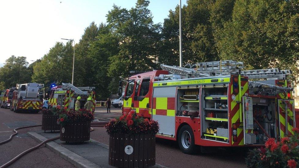 Firefighters wait outside city hall