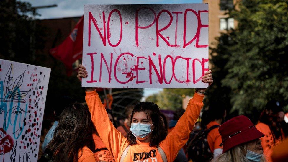 A woman holds a placard during the "Every Child Matters" march to mark the first National Day for Truth and Reconciliation in Montreal, Canada on September 30, 2021