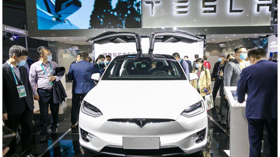 People view a Tesla Model 3 electric car at the auto exhibition area of the third International Import Expo in Shanghai, China, Nov. 6, 2020.