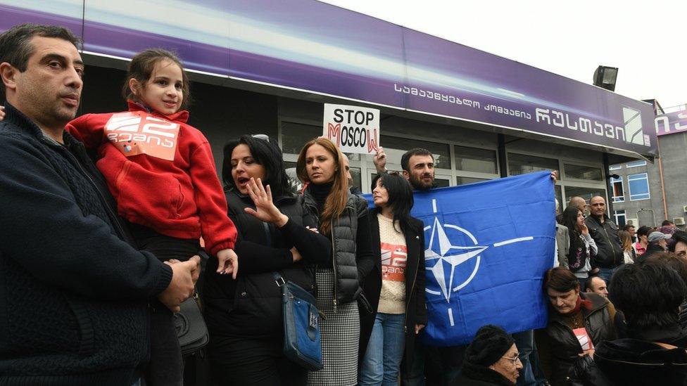 People take part in a rally near a studio building of Rustavi 2 TV station in Tbilisi on October 22, 2015.