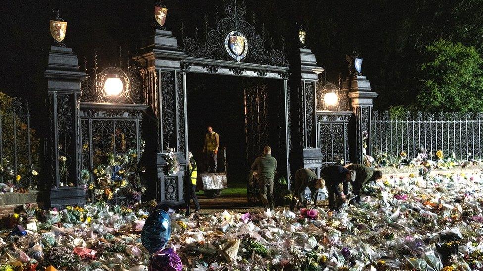 The Sandringham Estate gardens team in the process of moving floral tributes from the Norwich Gates