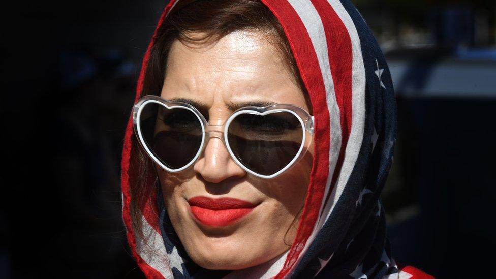 A woman wears an American flag for a headscarf as she participates in the #NoMuslimBanEver rally in downtown Los Angeles