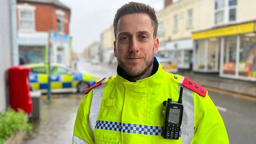 Inspector Marcus Forbes-George in high-vis police uniform in front of a police car