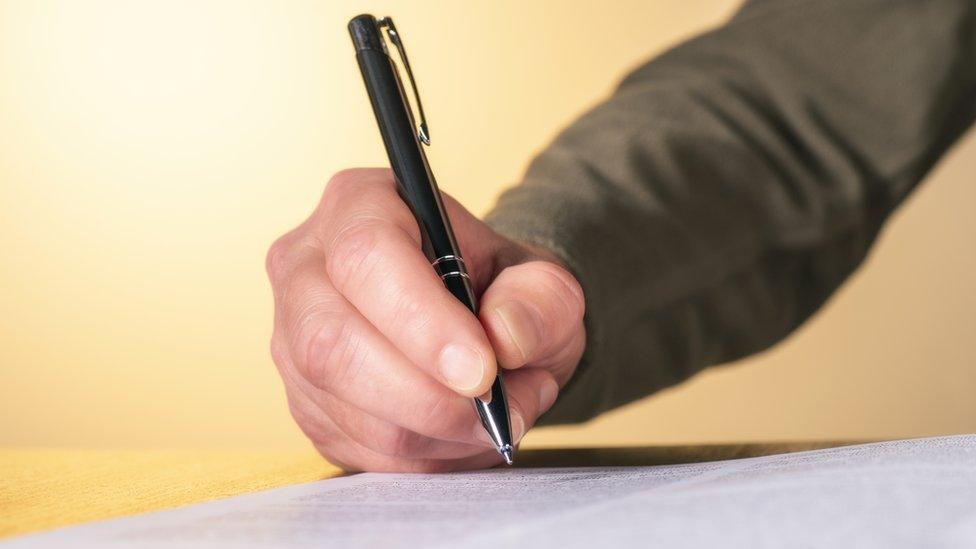 A man handwriting a letter