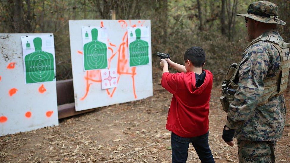 11-years-old Ashton (L), son of the former marine and the leader of the Georgia Security Forces (GSF) Chris Hill also known as General Bloodagent, takes part in a real gun target practice with the guidance of his father during a military drill in a forest with other group members in Flovilla, Georgia, USA on November 12, 2016.