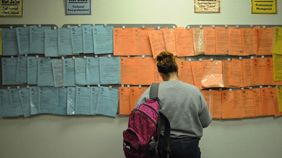 A woman looks at a local job board in 2008