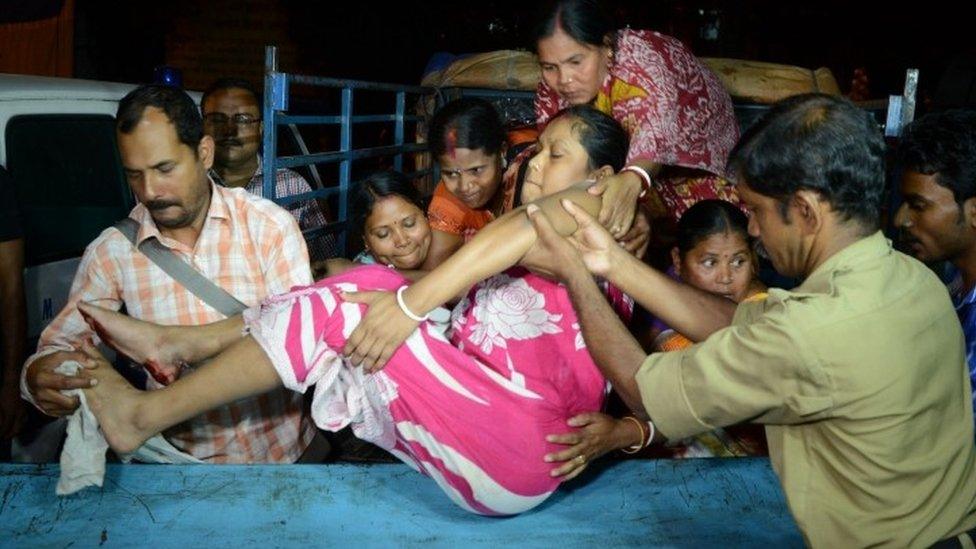 Indian rescuers help an earthquake victim in Siliguri, West Bengal (13 April 2016)