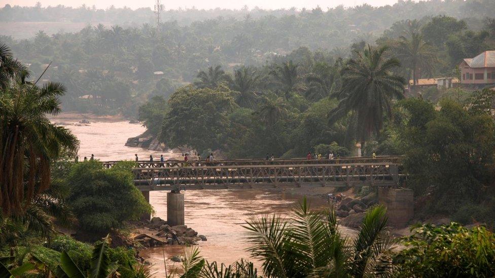 People walk across the Kasai Bridge linking the two sides of Tshikapa, Democratic Republic of Congo on July 28, 2017.