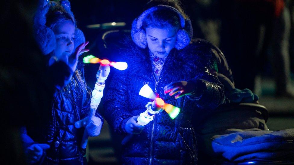 Children with hand-held illuminations