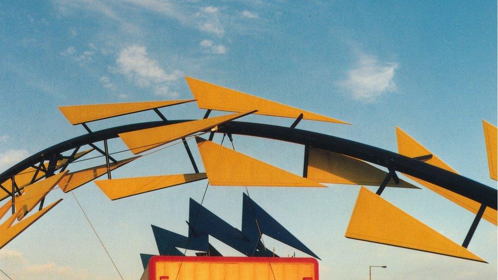 Part of the Blue Flash Power Box and Meshchips sculpture - a metal arch with yellow triangles attached.