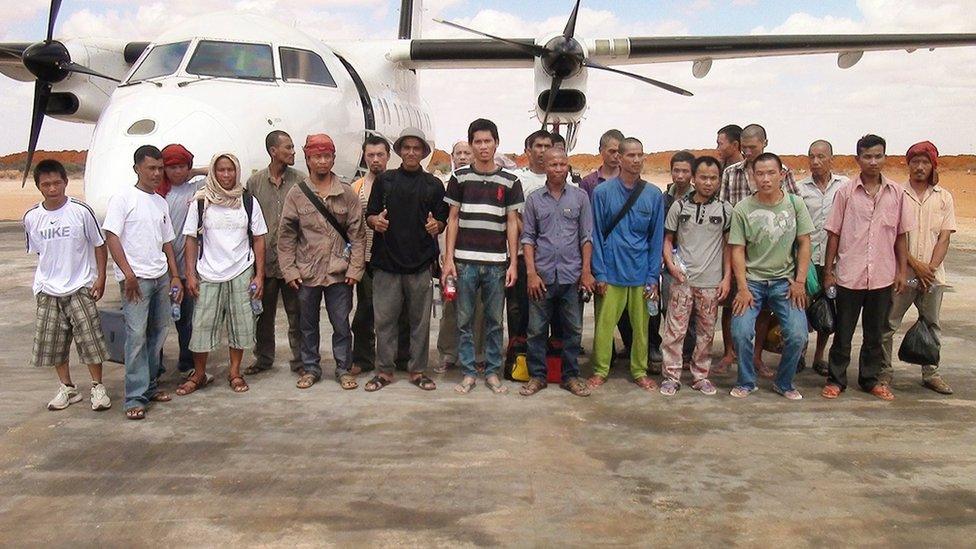 Sailors who had been held hostage by pirates for more than four years, stand for a group photograph as they prepare to board an airplane after being released in Galkayo, Somalia Sunday, 23 October 2016.